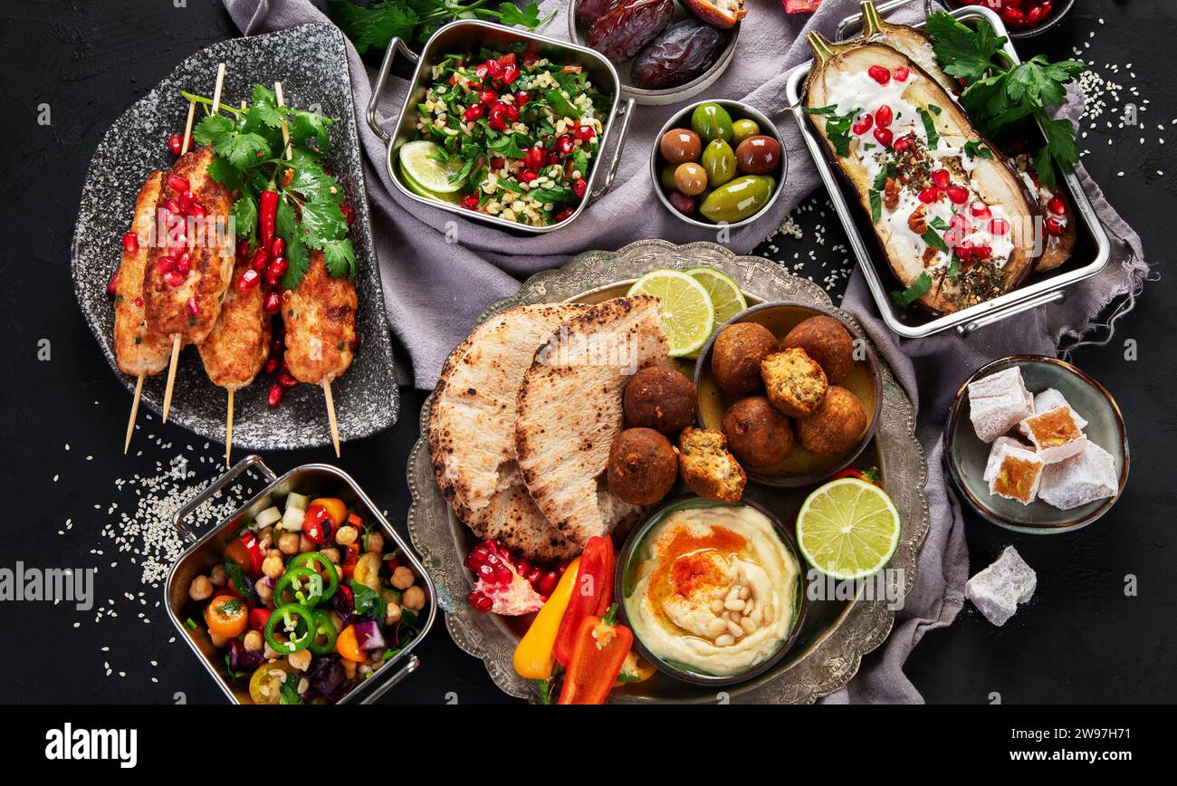 Piatti del medio Oriente o dell'arabo su sfondo nero. Gustoso concetto di cibo tradizionale. Pview superiore Foto Stock