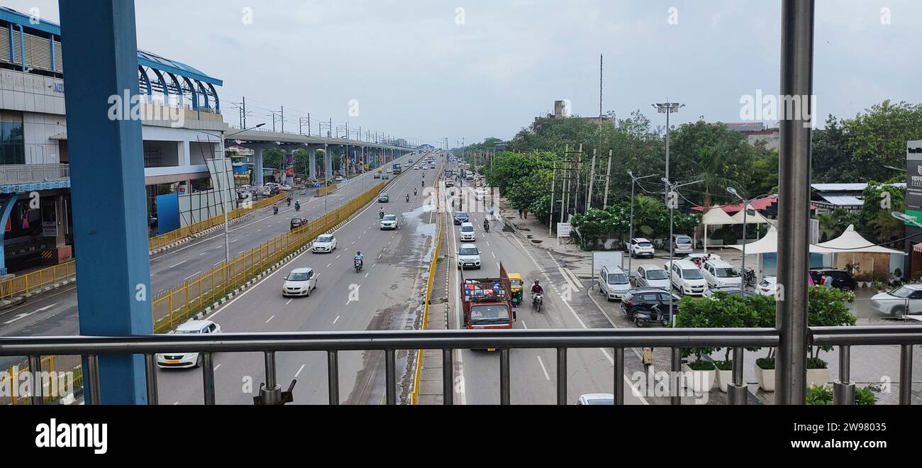 Una vista panoramica del paesaggio urbano da un balcone, caratterizzato da una vivace strada urbana in primo piano Foto Stock