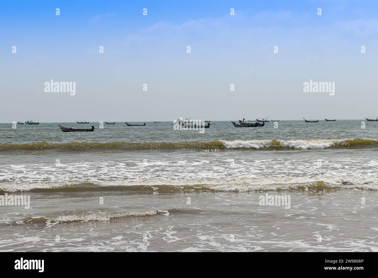 Un gruppo di persone è riunito in un gruppo di piccole barche in un ambiente tranquillo sull'oceano, creando un'atmosfera tranquilla Foto Stock