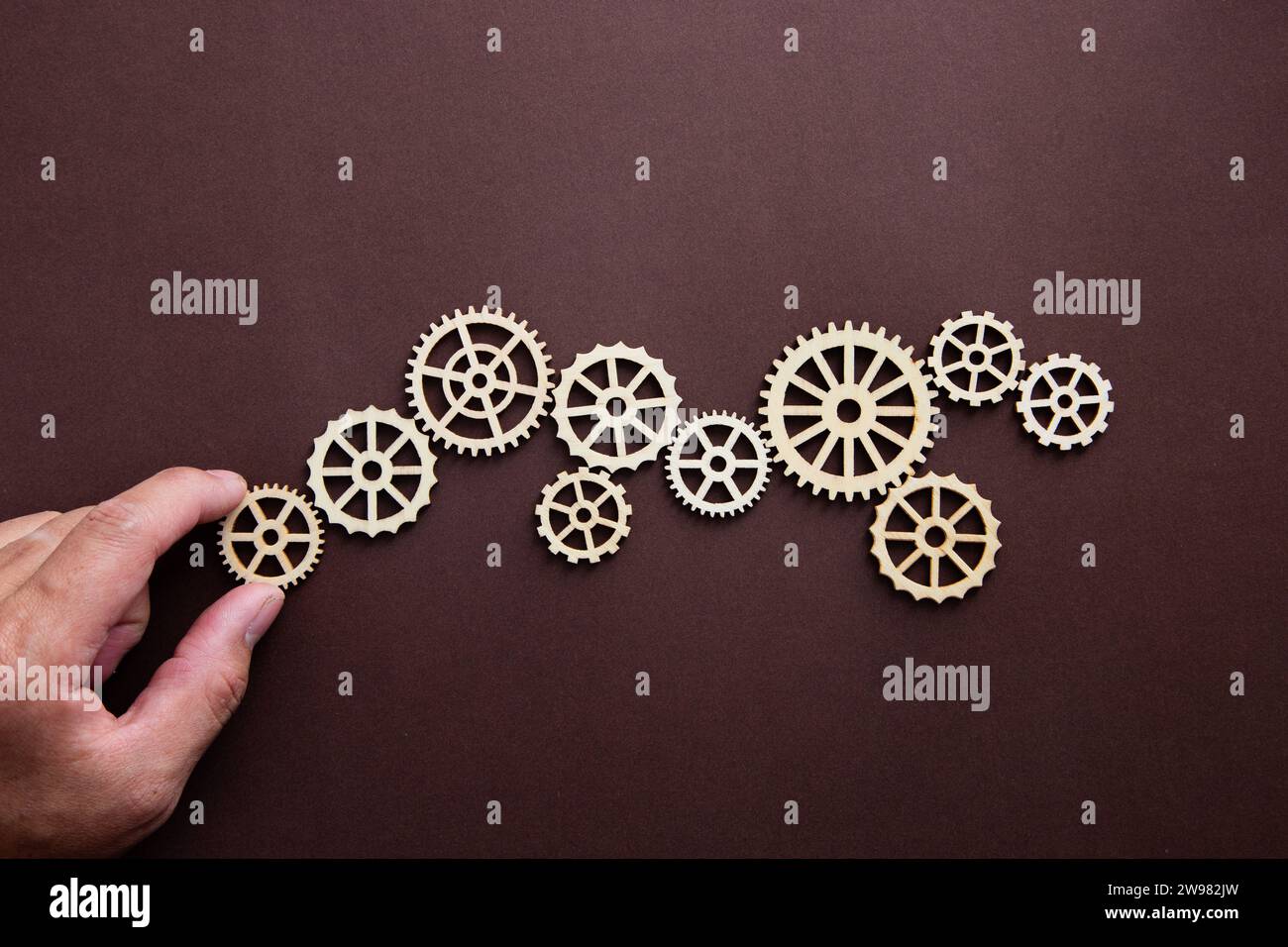 Automazione dei processi aziendali e dei flussi di lavoro con diagramma di flusso. Gestione dei processi a flusso di ingranaggi in legno con supporto manuale. Foto Stock