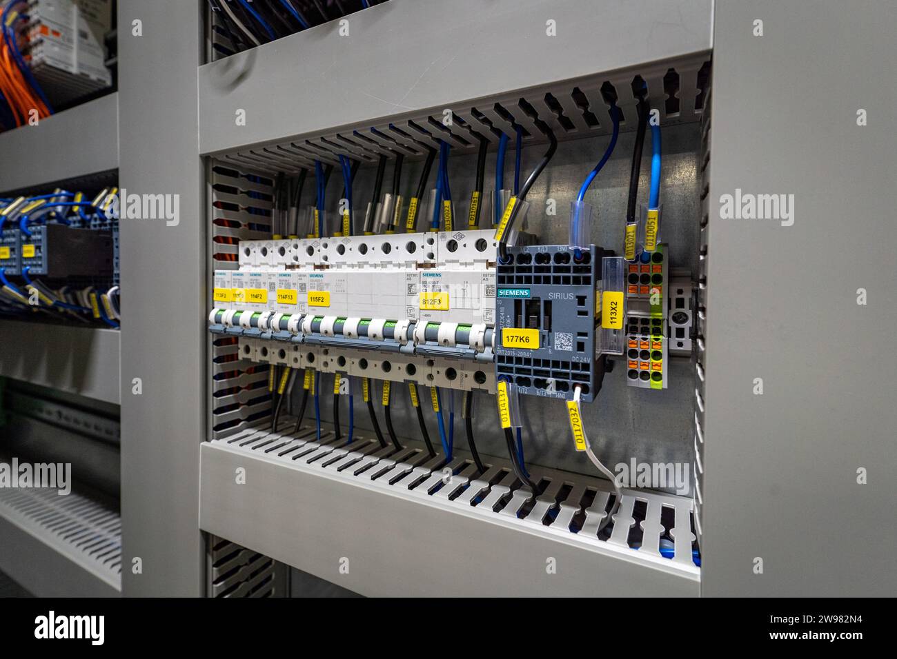 Un primo piano di una varietà di cavi elettrici, cavi e fili all'interno di un armadio elettronico Foto Stock