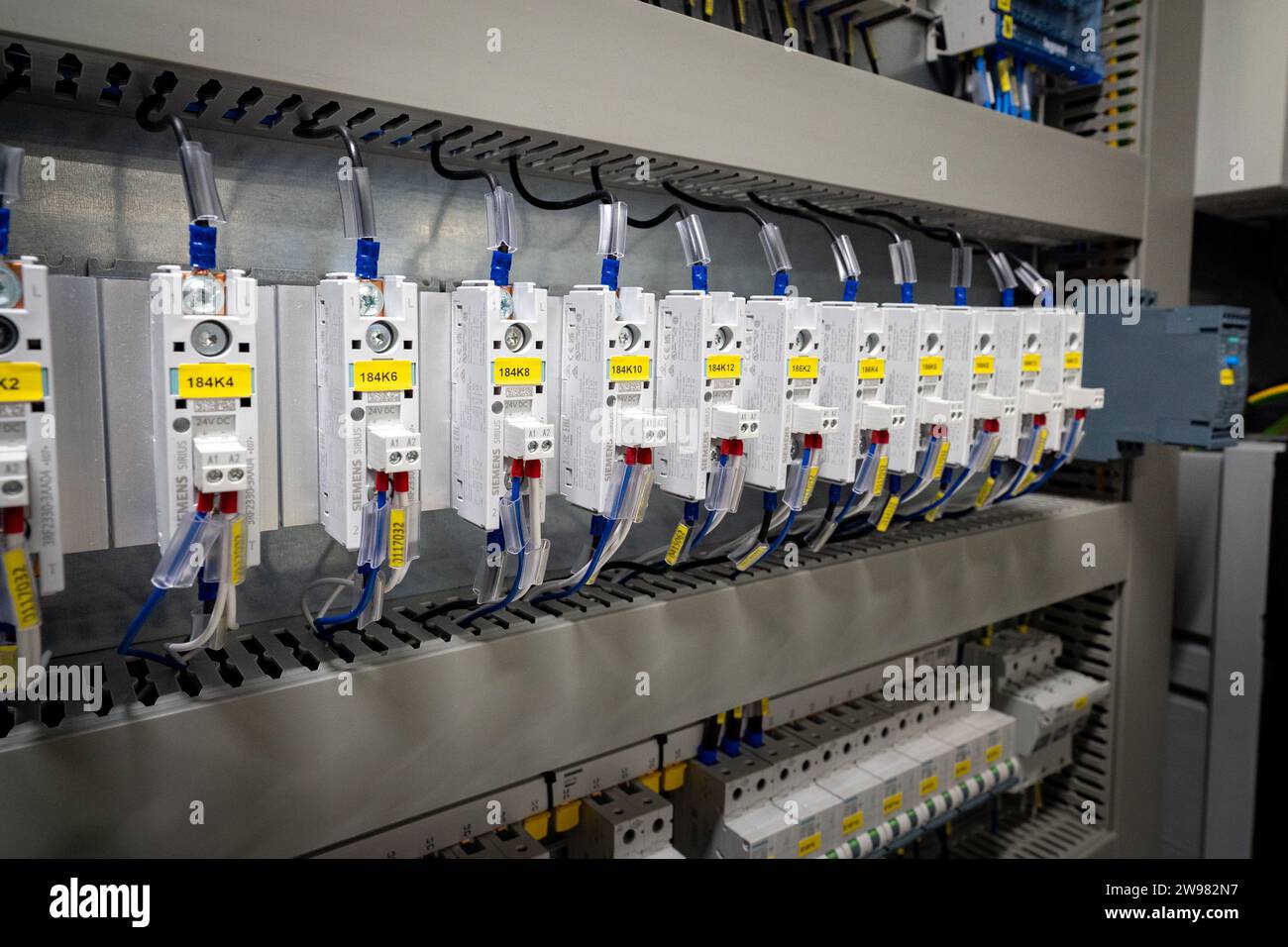 Un primo piano di una varietà di cavi elettrici, cavi e fili all'interno di un armadio elettronico Foto Stock
