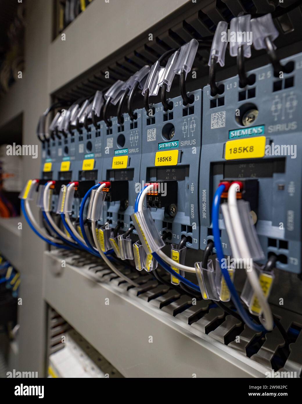 Un primo piano di una varietà di cavi elettrici, cavi e fili all'interno di un armadio elettronico Foto Stock