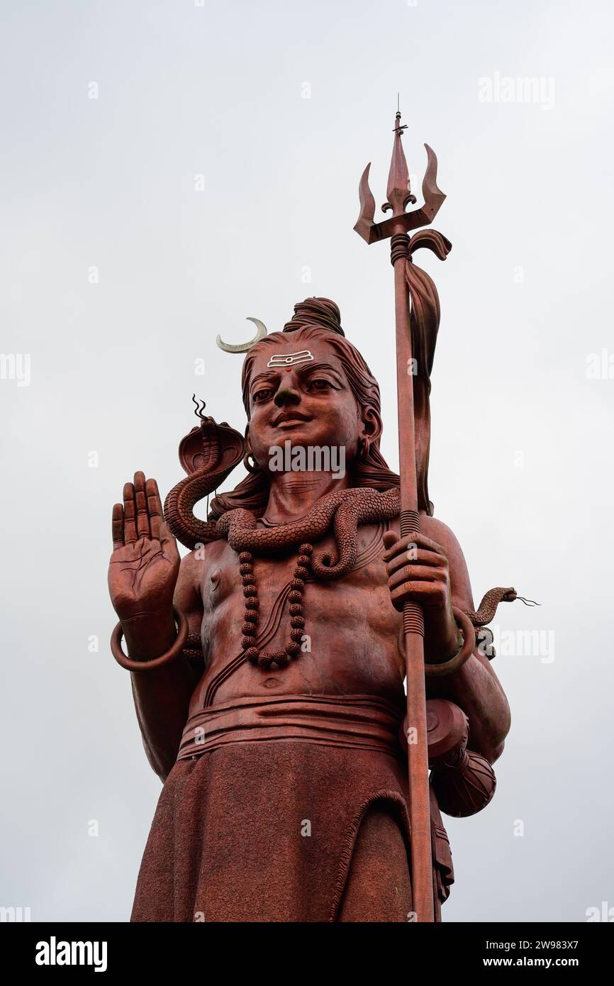 Statua del Signore Rosso Shiva con Tridente a Ganga Talao o Grand Bassin Mauritius Foto Stock