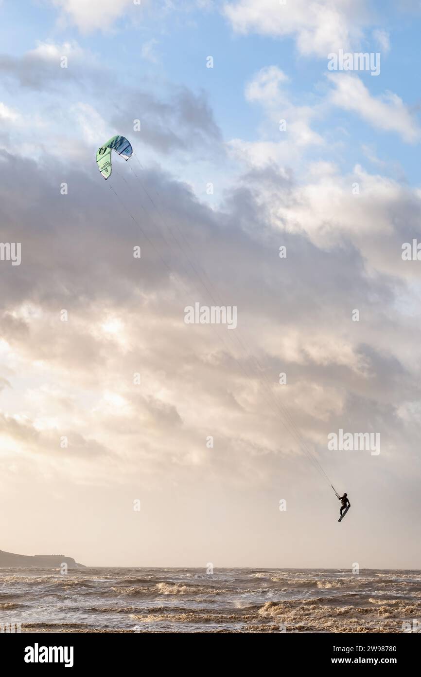 Weston super Mare, Regno Unito. Un Kitesurfer o Kiteboarder sfrutta i forti venti durante Storm Pia per fare un salto in alto sulle onde del mare Foto Stock