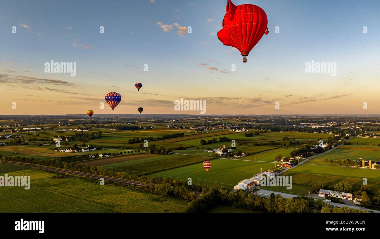 Una veduta aerea delle mongolfiere che galleggiano via è una testa di maiali, nella Pennsylvania rurale all'alba in una soleggiata mattinata estiva Foto Stock