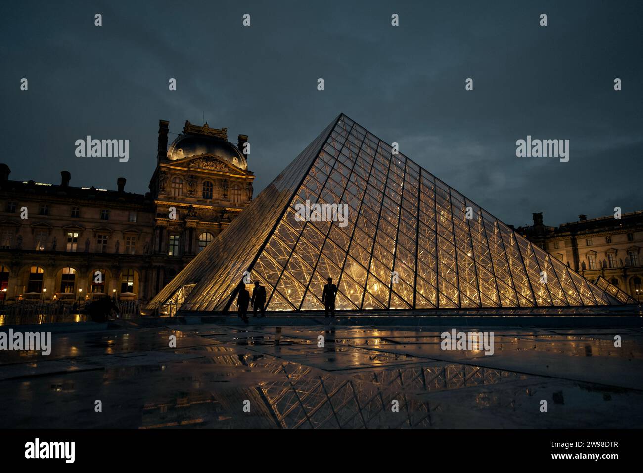 Una vista notturna dell'iconico Museo del Louvre di Parigi, illuminato da luci brillanti Foto Stock