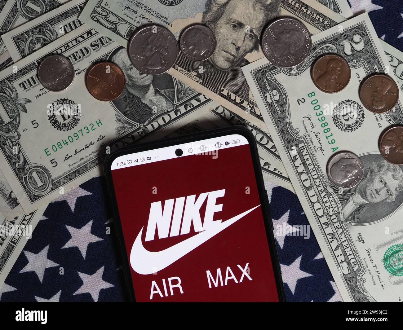 Baviera, Germania - dicembre 25. 2023: In questa foto, un logo Nike Air Max è visibile su uno smartphone con note in dollari statunitensi A. Foto Stock
