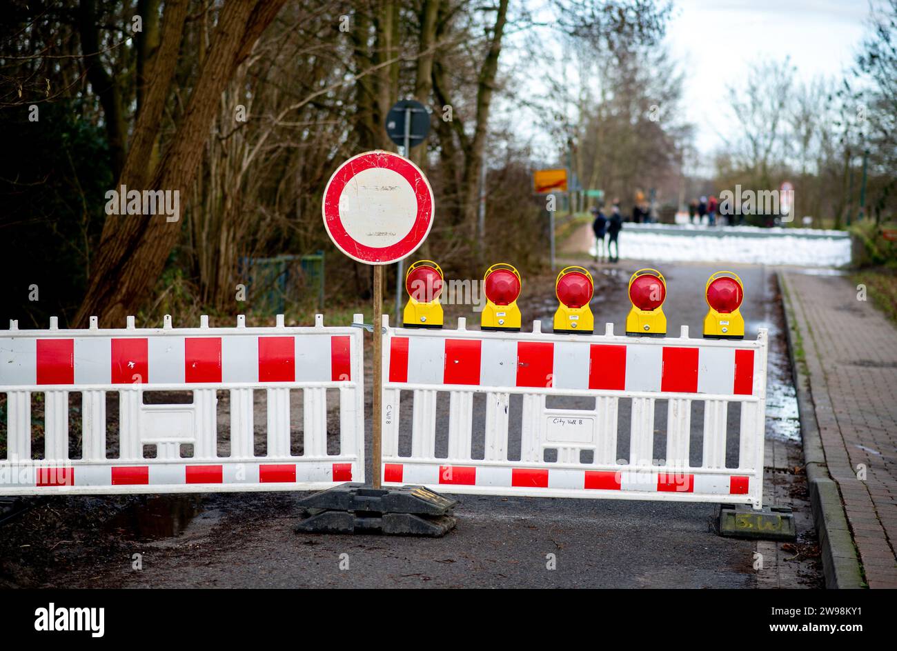 Wardenburg, Germania. 25 dicembre 2023. I segnalatori luminosi si trovano di fronte a un argine chiuso sul fiume Hunte. La situazione delle alluvioni rimane tesa in molte regioni della bassa Sassonia durante le vacanze di Natale. Credito: Hauke-Christian Dittrich/dpa/Alamy Live News Foto Stock