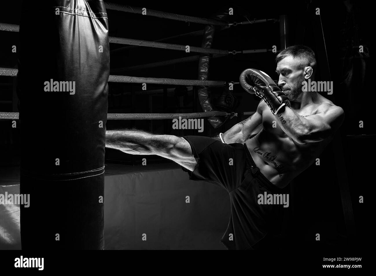 Kickboxer prende il piede. Allenare un atleta professionista. Il concetto di mma, wrestling, muay thai. Supporti misti Foto Stock