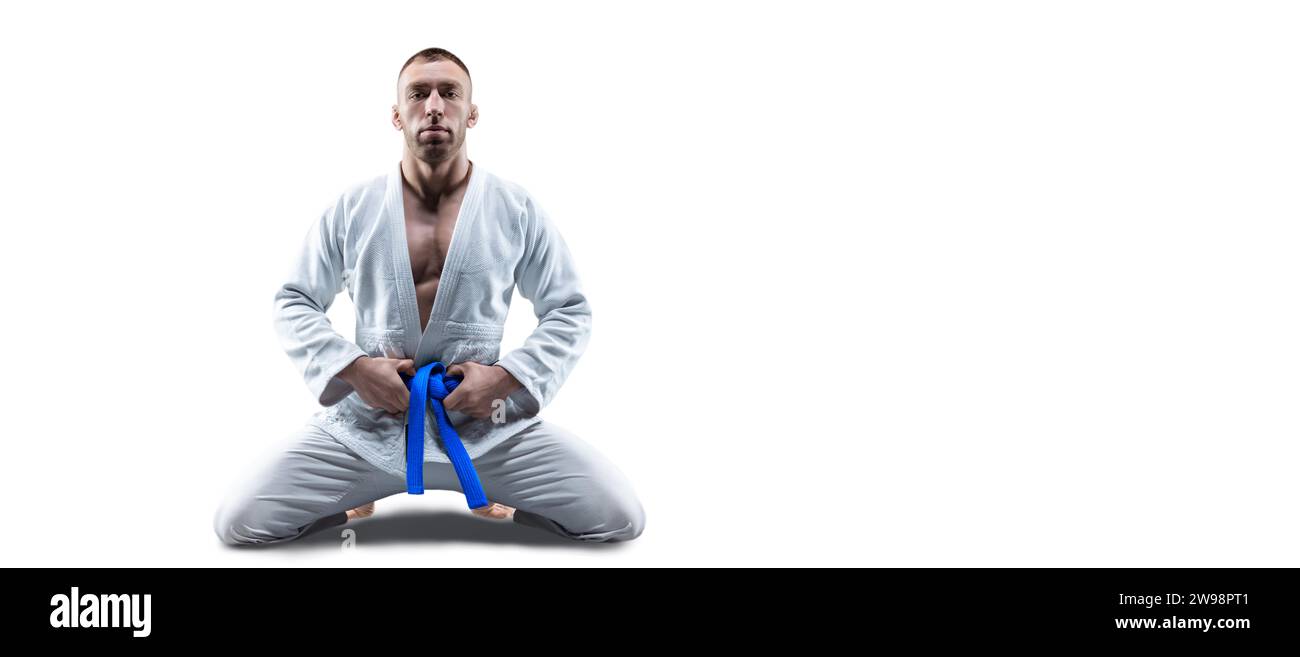 L'atleta indossa un kimono con una cintura blu e aspetta l'avversario. Concetto di karate, sambo, jujitsu. Supporti misti Foto Stock