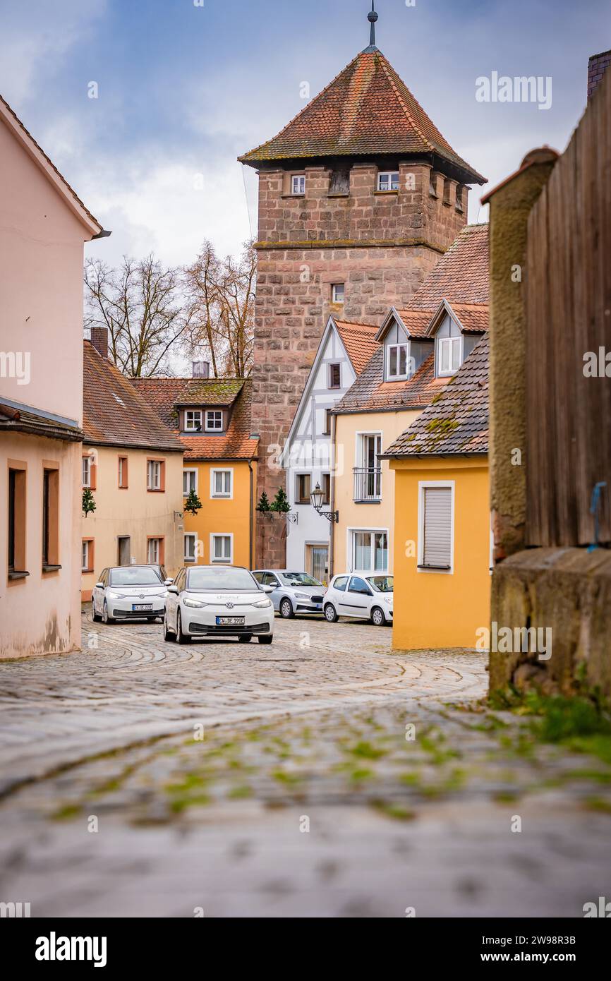 Auto da condivisione con cervi e vista attraverso un vicolo della città vecchia con auto parcheggiate e ciottoli, Baviera, Germania Foto Stock