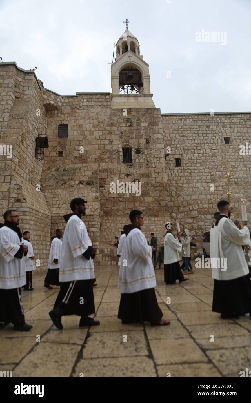 I palestinesi arrivano per gli eventi natalizi alla Chiesa della Natività i palestinesi arrivano per gli eventi natalizi alla Chiesa della Natività il 24 dicembre 2023 a Betlemme, Cisgiordania. Il mese scorso, i leader cristiani palestinesi hanno indetto le celebrazioni pubbliche di Natale, citando gli effetti della guerra in corso a Gaza. Considerata dai cristiani come il luogo di nascita di Gesù, Betlemme è di solito affollata di turisti stranieri in questo periodo dell'anno, con strade piene di decorazioni natalizie e venditori ambulanti che vendono ornamenti e figurine festive. La guerra di Israele contro Hamas scatenata dagli attacchi del 7 ottobre ha avuto luogo Foto Stock