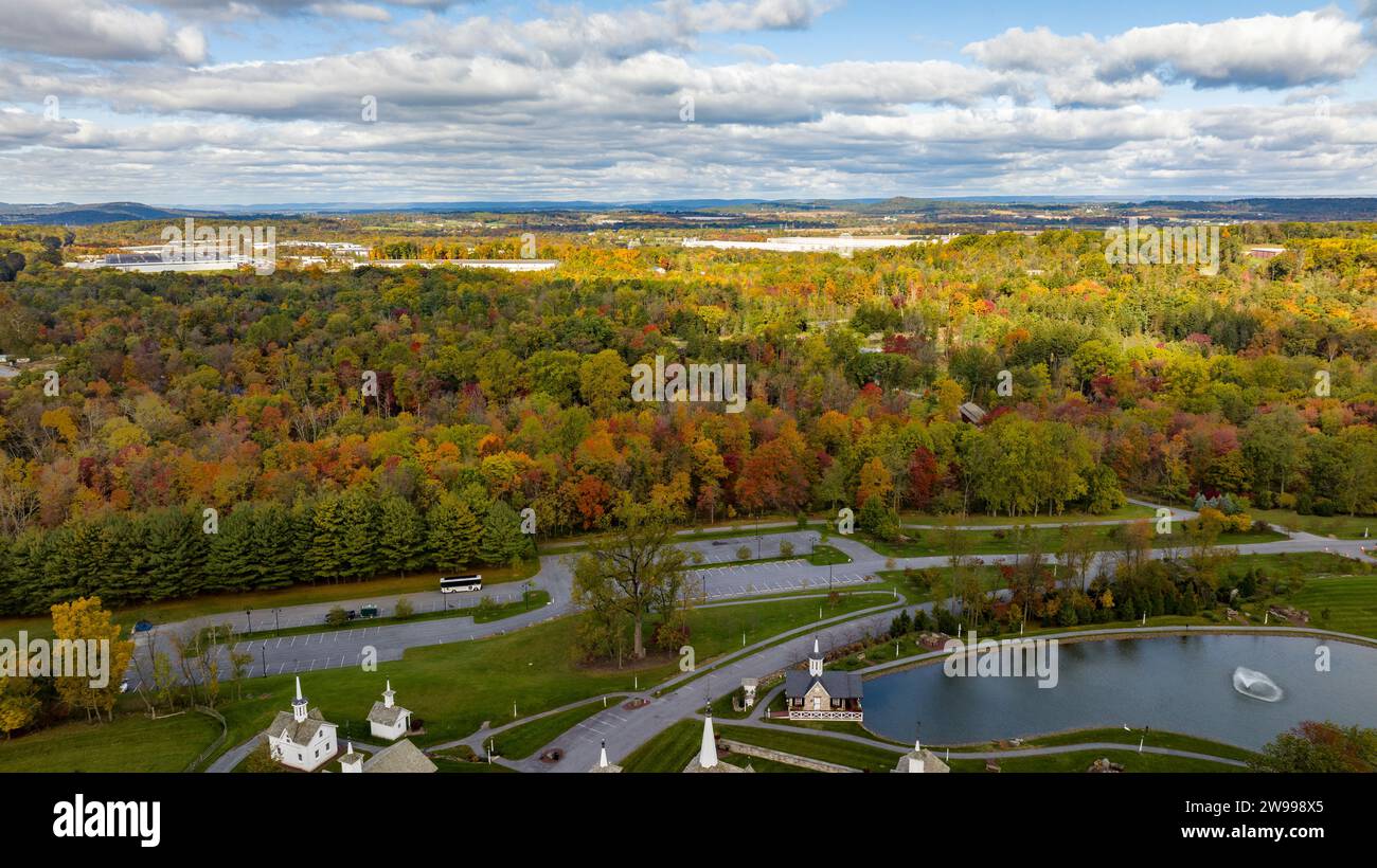 Una scenografia pittoresca caratterizzata da un tranquillo laghetto circondato da alberi autunnali ed edifici sullo sfondo Foto Stock