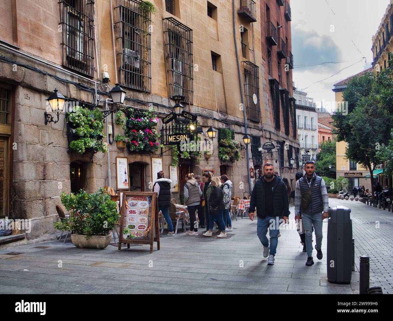 Gli emigranti camminano in una vecchia e accogliente strada di Madrid, in Spagna Foto Stock
