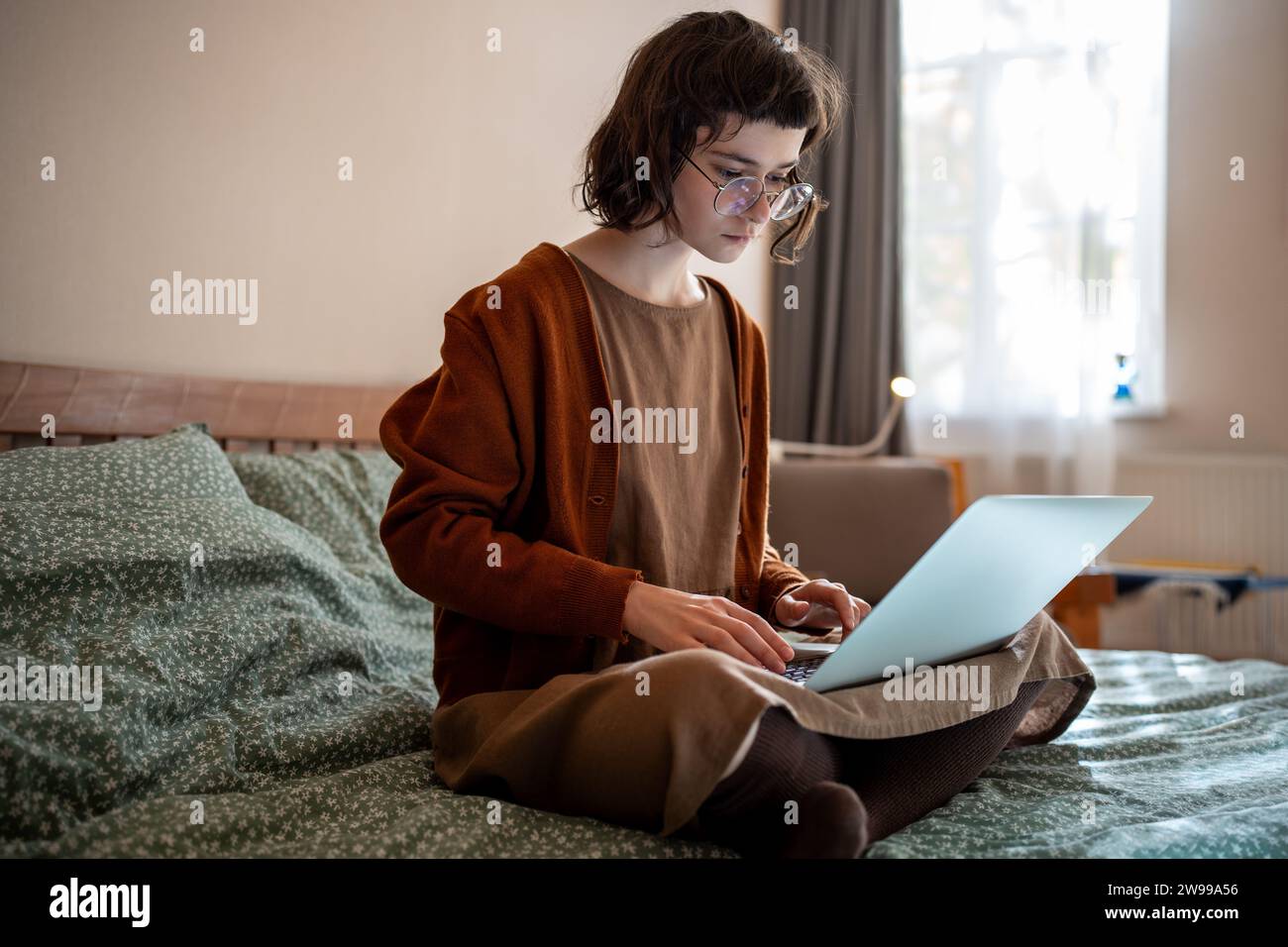 Concentrata adolescente pensiva che lavora come freelance, studia online a casa utilizzando un computer portatile Foto Stock