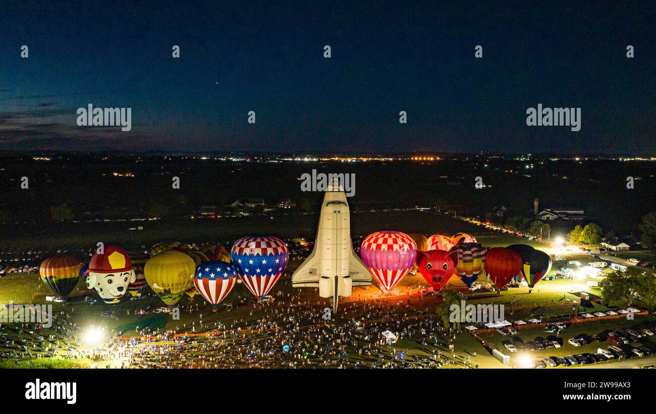Una vista aerea delle mongolfiere che fanno un balloon blow notturno con uno stadio di canter in mongolfiera dello Space Shuttle, in una serata estiva Foto Stock