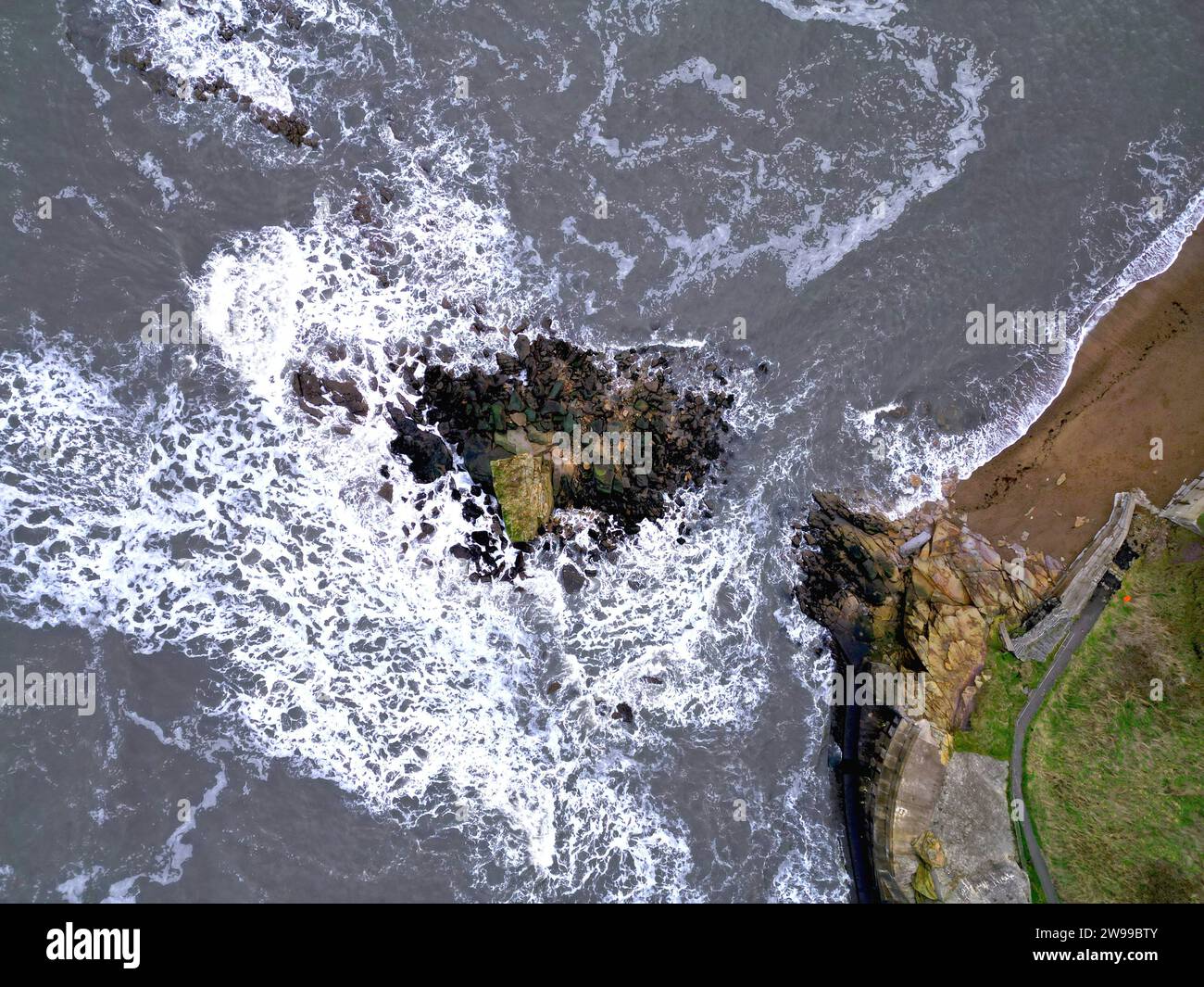 Vista aerea delle rocce e delle onde oceaniche. Charley's Garden, Collywell Bay, Seaton Sluice Foto Stock