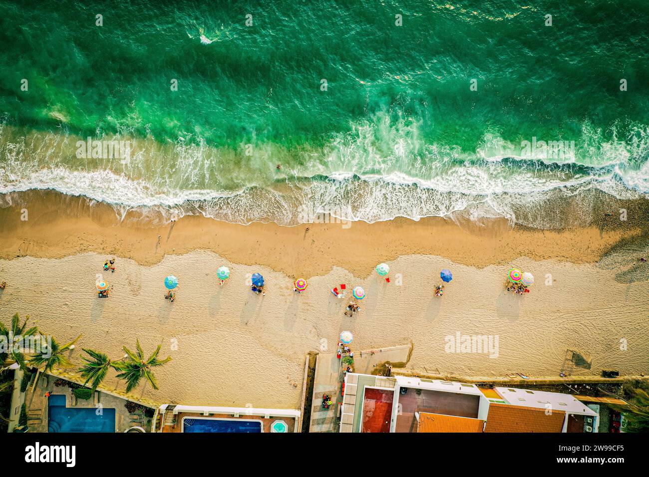 Foto aerea dall'alto verso il basso della spiaggia e dell'oceano colorato con ombrelloni Foto Stock