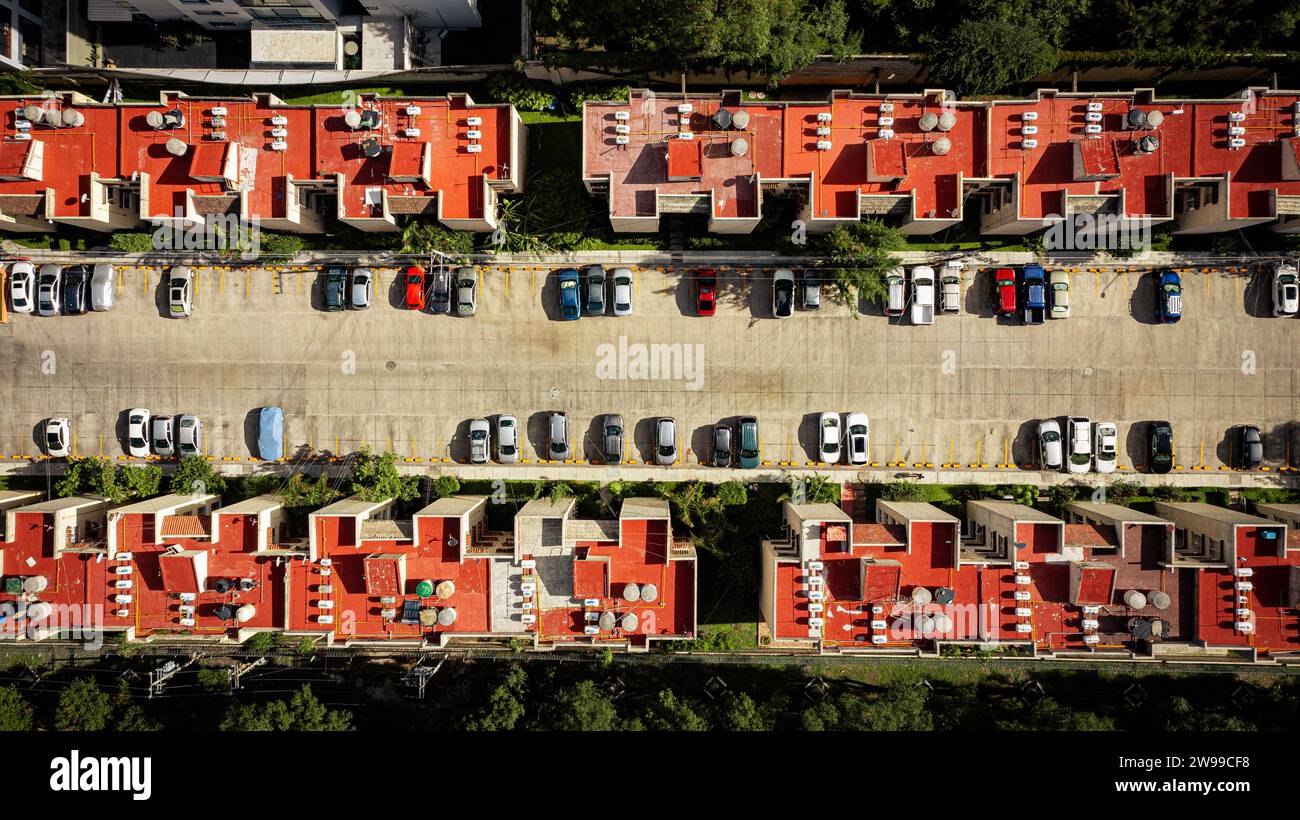 Droni dall'alto in basso di condominio con tetti rossi e parcheggi. Foto Stock