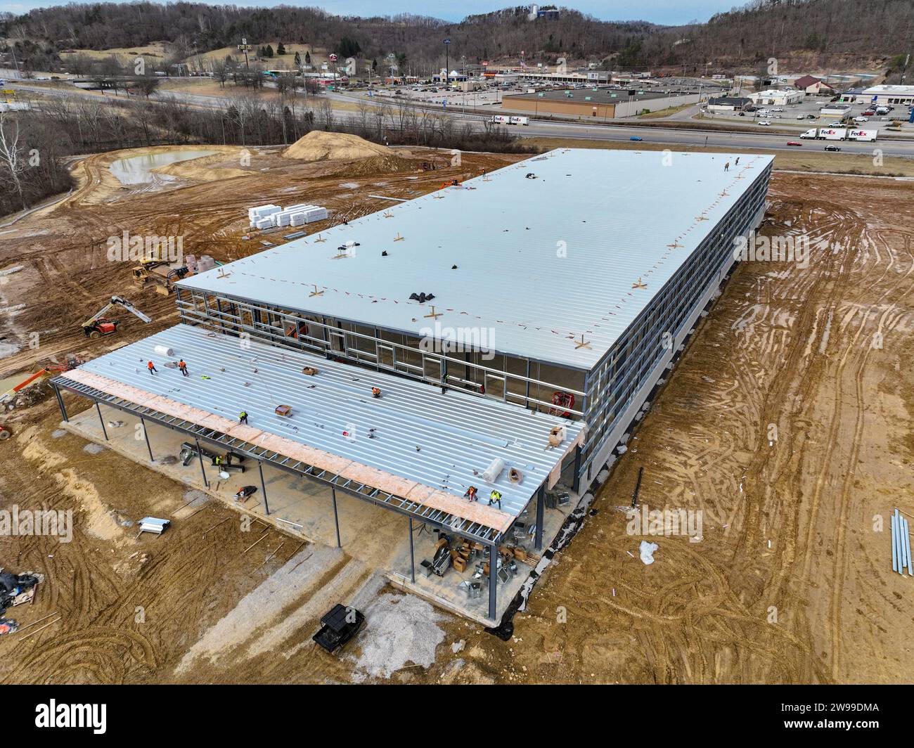 Una vista dall'alto della base di un vasto impianto industriale, con materiali e macchine movimento terra che punteggiano la prima costruzione Foto Stock