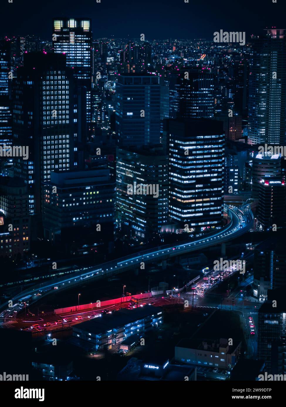 Una vista aerea di una vivace città illuminata dalle luci luminose degli alti grattacieli. Giappone Foto Stock