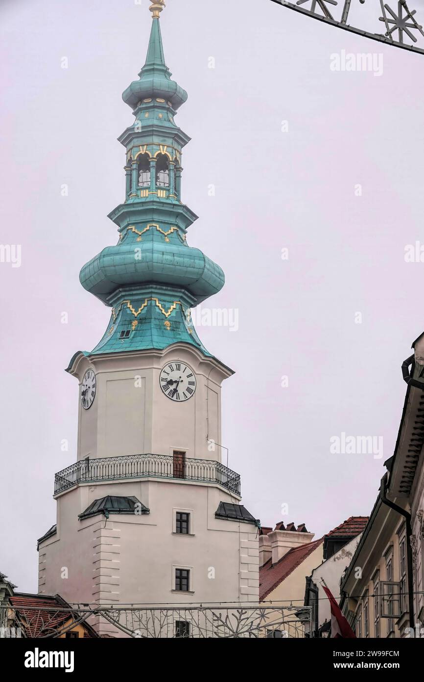 Una vista mozzafiato di due torri dell'orologio contro un cielo nuvoloso a Bratislava, Slovacchia. Foto Stock