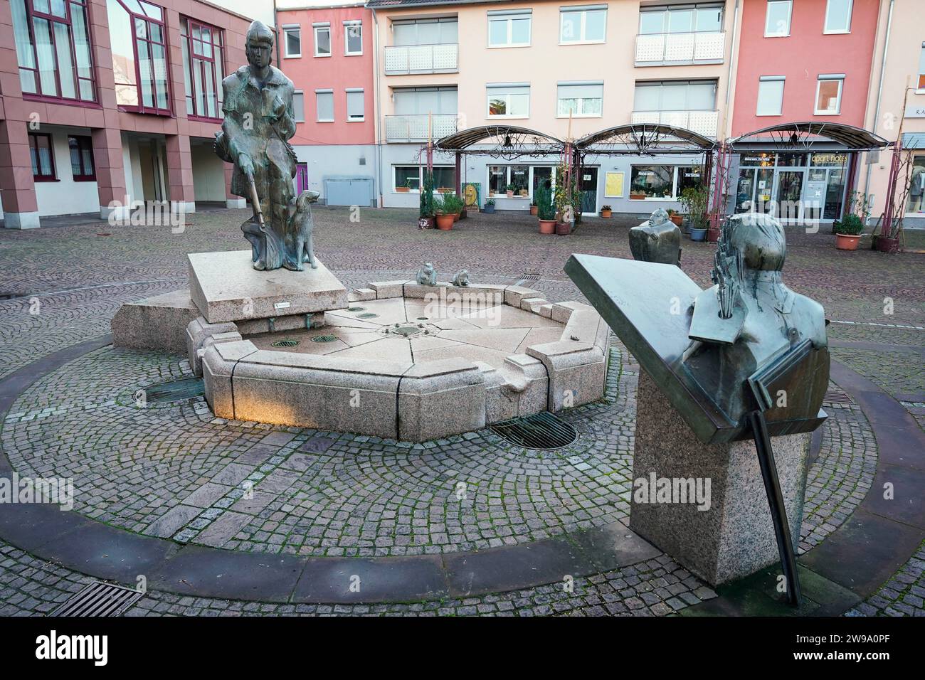 Edenkoben, Germania. 20 dicembre 2023. Le figure della fontana della Calza di Eterna si trovano in una piazza nel centro della città. Quando l'autore James Fenimore Cooper portò la sua calza di ferro alla vita letteraria nel 1823, combinò la storia selvaggiamente romantica con la critica alla civiltà e alla distruzione della natura. Il sentiero del ranger conduce alla Southern Wine Route? Crediti: Uwe Anspach/dpa/Alamy Live News Foto Stock