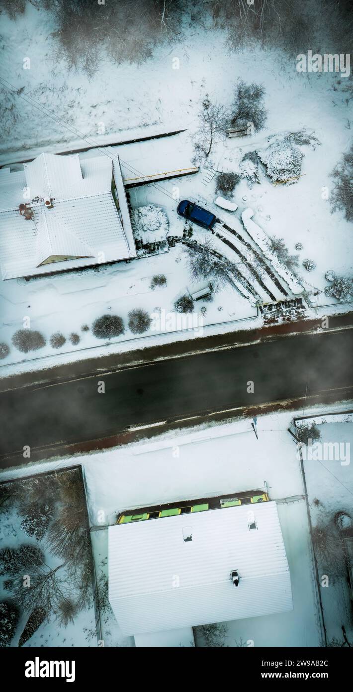 Foto aerea di una strada coperta di neve accanto a due Una casa a forma di macchina Foto Stock