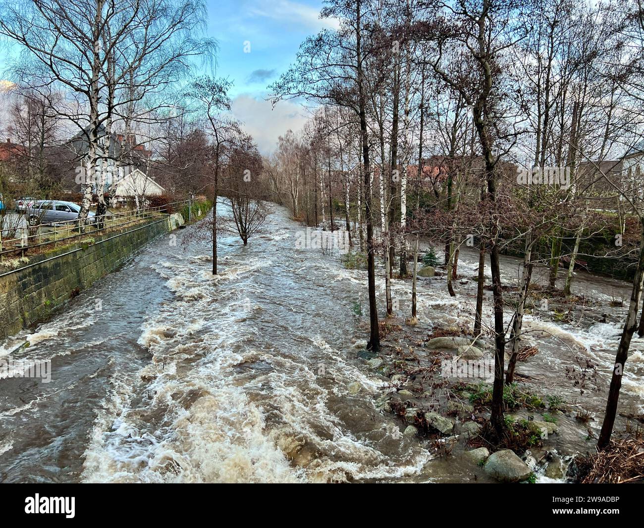 Oker, Germania. 26 dicembre 2023. L'inondazione di Oker inonda parzialmente il lungomare di Oker. L’Agenzia statale della bassa Sassonia per la gestione delle acque, la protezione delle coste e la conservazione della natura (NLWKN) ha avvertito di un ulteriore peggioramento della situazione delle inondazioni nei bacini fluviali dell’Oker e dell’Innerste. Crediti: Thomas Schulz/dpa/Alamy Live News Foto Stock