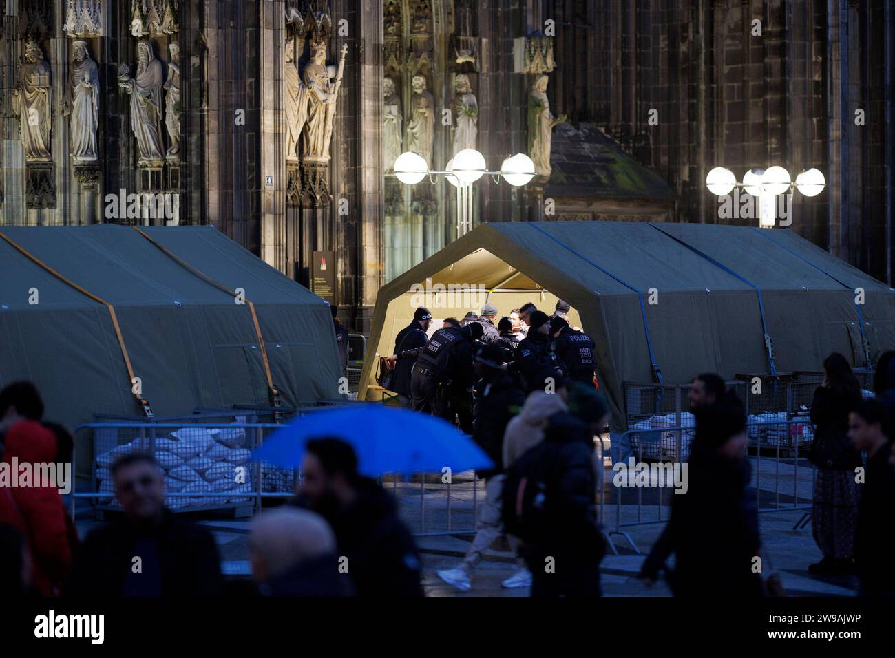 Terroralarm zu Weihnachten: Rund um den Kölner dom sind Polizisten zu sehen. Besucher des Doms müssen sich in Zelten Kontrollen unterziehen. Hintergrund: Eine islamistische Terrorzelle des afghanischen ISIS-Ablegers ISPK soll über den Jahreswechsel u.a. in Köln Anschläge geplan haben. Themenbild, Symbolbild Köln, 25.12.2023 NRW Deutschland *** allerta terroristica a Natale agenti di polizia possono essere visti intorno alla Cattedrale di Colonia i visitatori della cattedrale devono sottoporsi a controlli in tende sullo sfondo una cellula terroristica islamista della filiale afghana ISIS ISPK si dice abbia pianificato attacchi a Colonia, amon Foto Stock