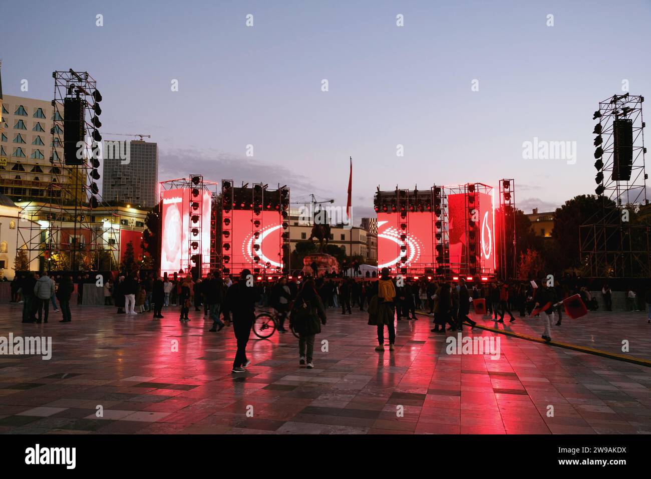 Tirana, Albania - 29 novembre 2023: La folla si riunisce accanto alla statua di Skanderbeg, in attesa di un concerto, con un palco allestito nelle vicinanze Foto Stock