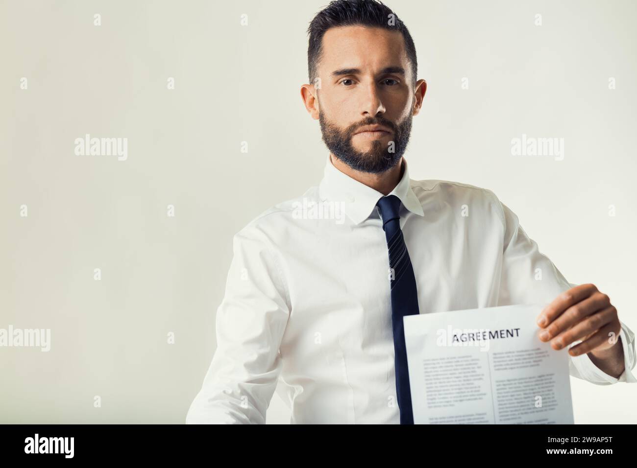Un uomo in abbigliamento da lavoro mostra un documento che indica un momento di negoziazione Foto Stock