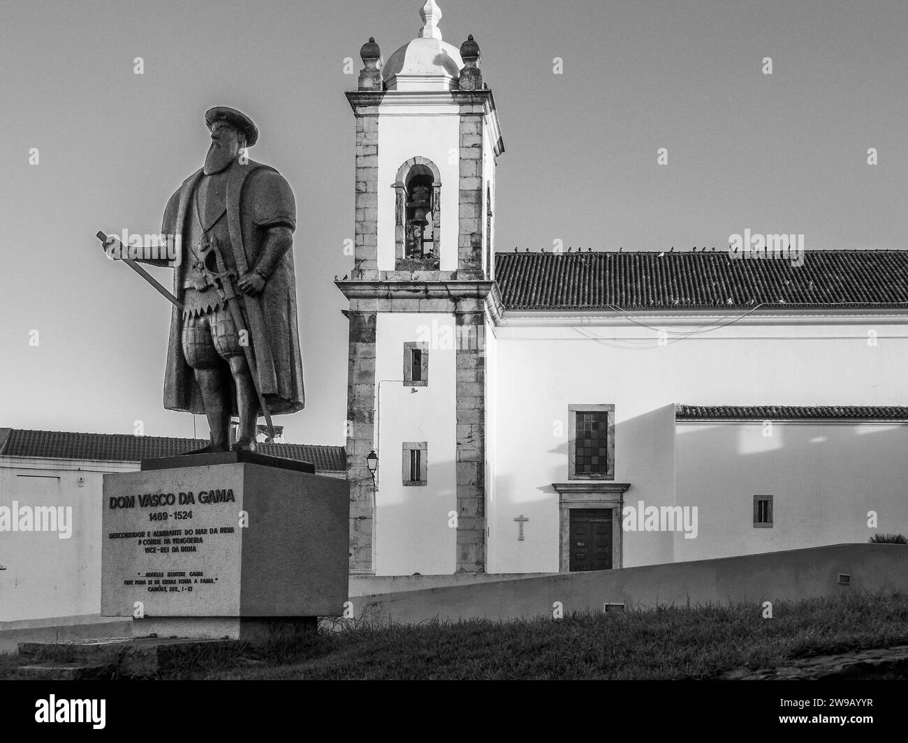 Statua di Dom Vasco da Gama con Igreja Matriz do Salvador de Sines chiesa cattolica nella città di Sines nella regione portoghese di Costa Azul Foto Stock