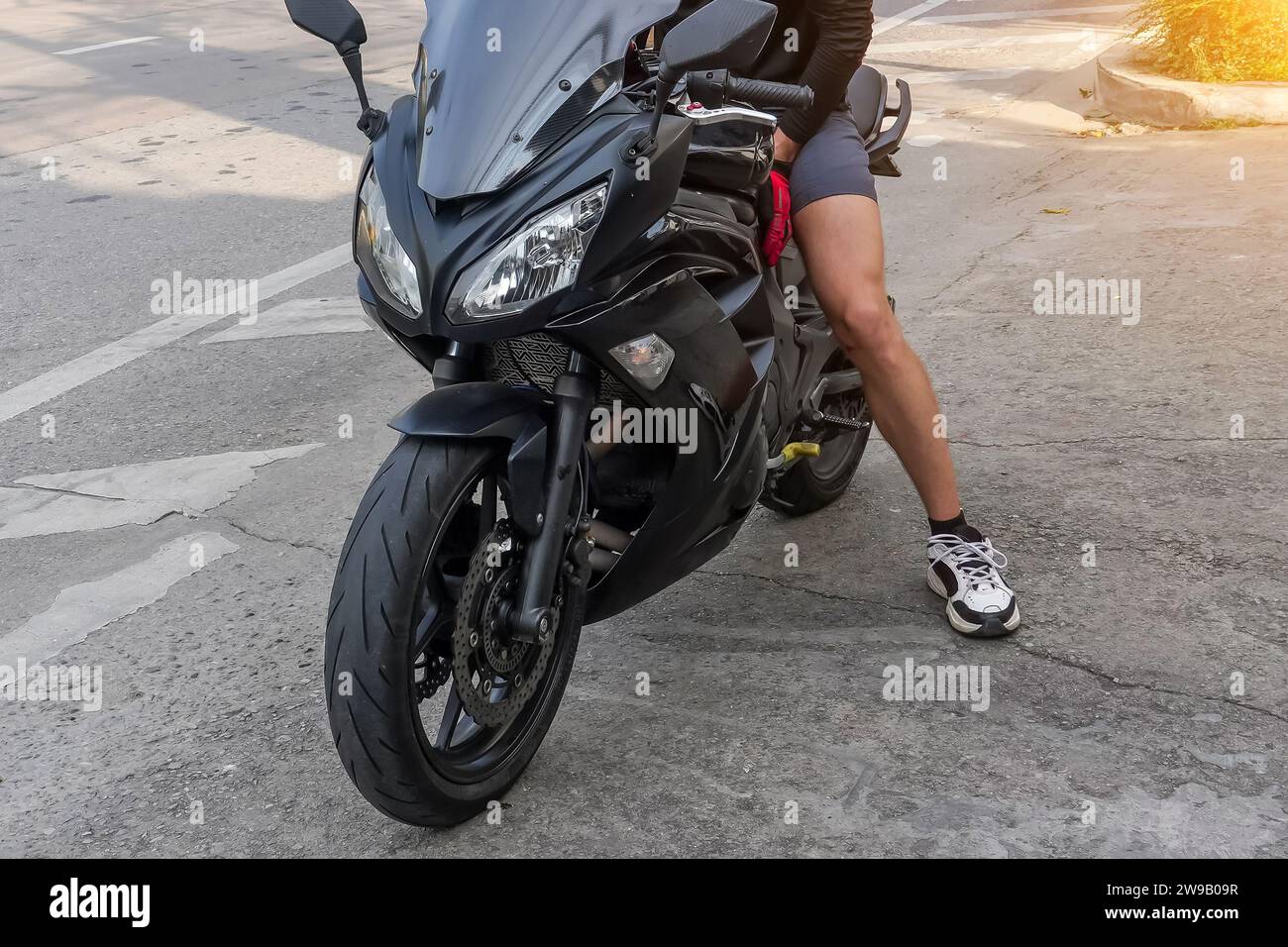 Uomo in moto in pantaloncini corti Foto Stock