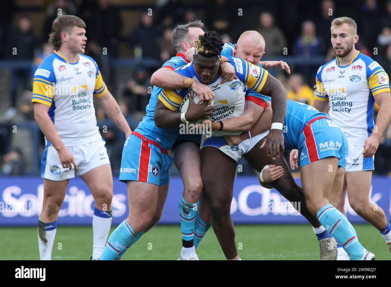 Leeds, Regno Unito. 26 dicembre 2023. AMT Headingley Stadium, Leeds, West Yorkshire, 26 dicembre 2023 Wetherby Whaler Festive Challenge Leeds Rhinos contro Wakefield Trinity Justin Sangare di Leeds Rhinos è affrontato da Wakefield Trinity Credit: Touchlinepics/Alamy Live News Foto Stock