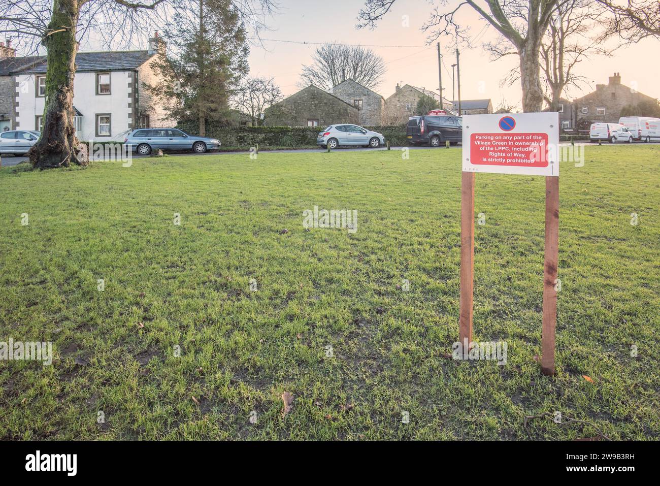 Viste contrastanti sulla segnaletica sui green del villaggio di Long Preston che fanno riferimento al parcheggio nelle varie aree verdi. Foto Stock