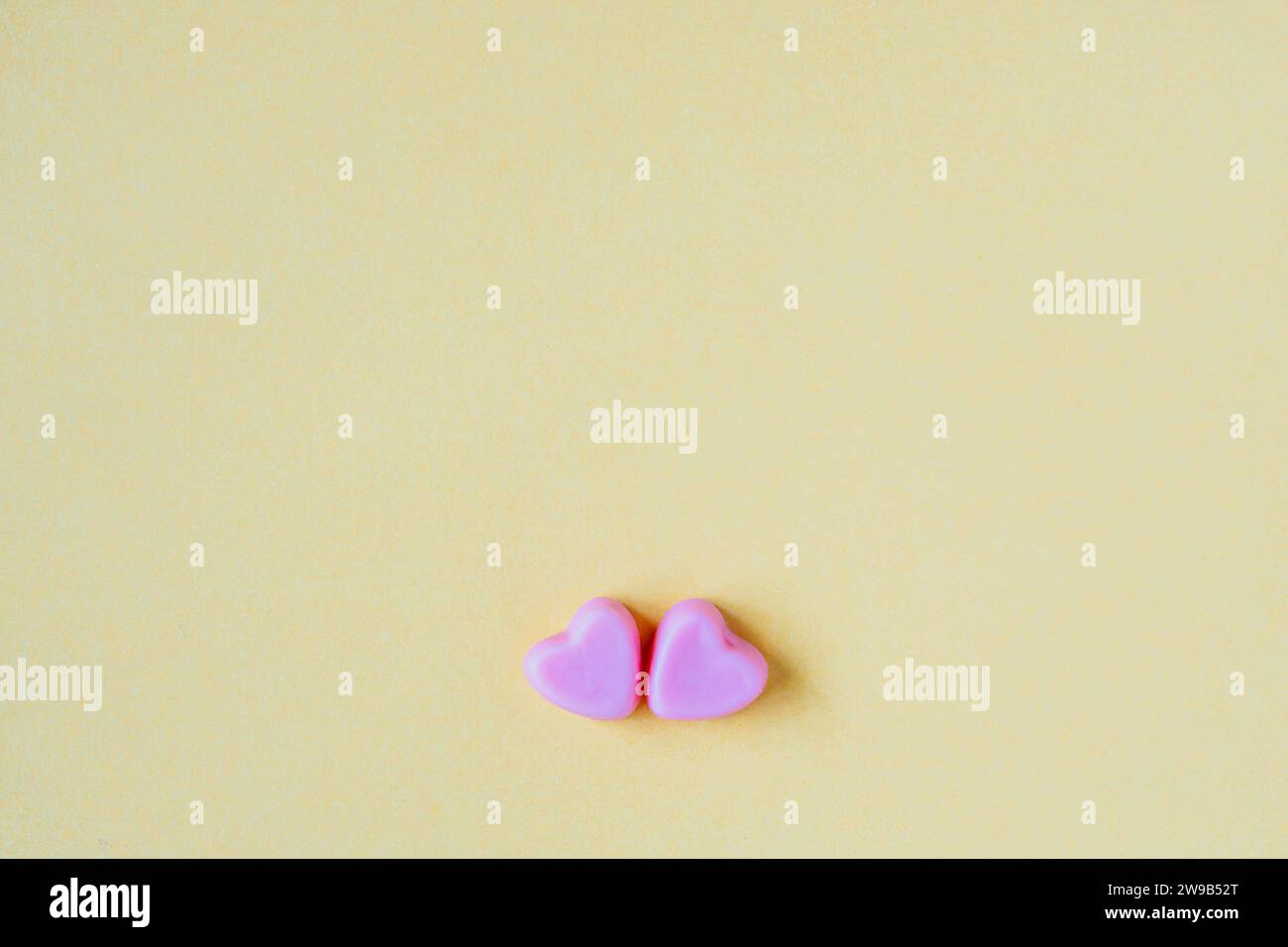 Sfondo San Valentino con caramelle a forma di cuore su sfondo giallo Foto Stock