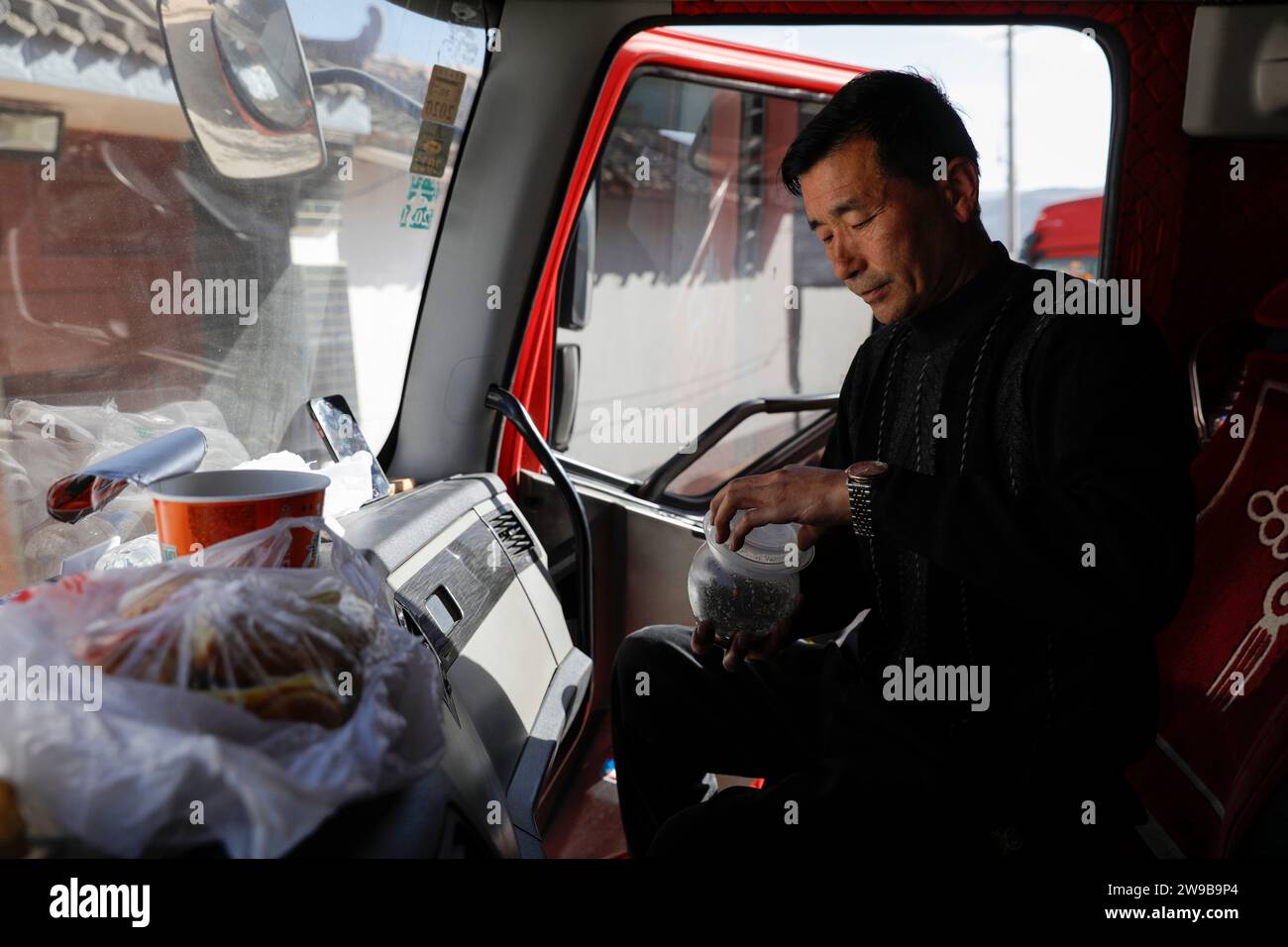 (231226) -- JISHISHAN, 26 dicembre 2023 (Xinhua) -- ma Ming si prepara a pranzare velocemente in attesa di essere scaricato in un punto di trasferimento prefabbricato nel comune di Liugou di Jishishan, provincia del Gansu della Cina nord-occidentale, 26 dicembre 2023. Ma Ming, 50 anni, è un camionista veterano con oltre 20 anni di esperienza a Yinchuan, capitale della regione autonoma Ningxia Hui della Cina nord-occidentale. Dopo che un terremoto di magnitudo 6,2 scosse la contea autonoma di Bonan-Dongxiang-Salar di Jishishan nella prefettura autonoma di Linxia Hui, provincia del Gansu della Cina nord-occidentale, ma Ming si offrì volontario per trasportare i soccorsi Foto Stock