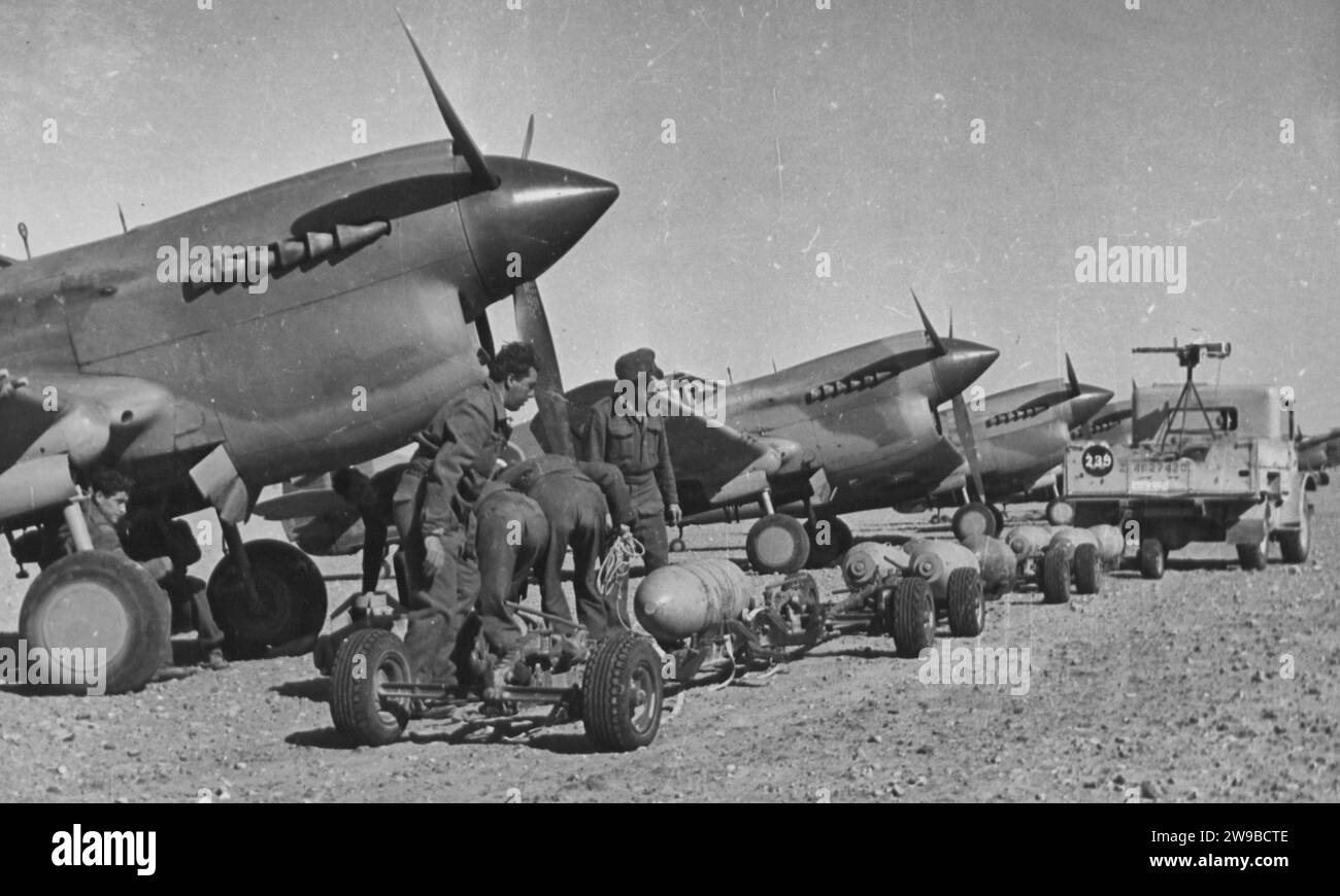 Item Trolley carico di bombe pronte per il caricamento su bombardieri da caccia in un avanzato atterraggio in Tripolitania. (Curtiss P-40). Le attività dei bombardieri da caccia sono state la caratteristica principale degli attacchi aerei alleati nell'attuale offensiva in Libia 1943 Foto Stock