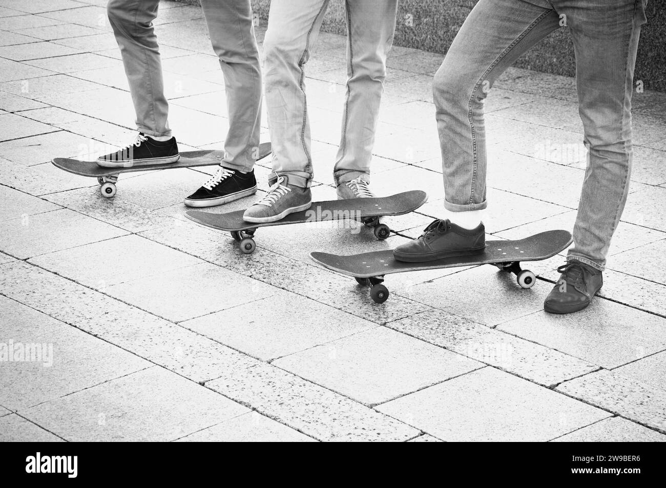 Un gruppo di skateboarder si sta avvicinando alle proprie tavole e si sta preparando per iniziare l'allenamento Foto Stock