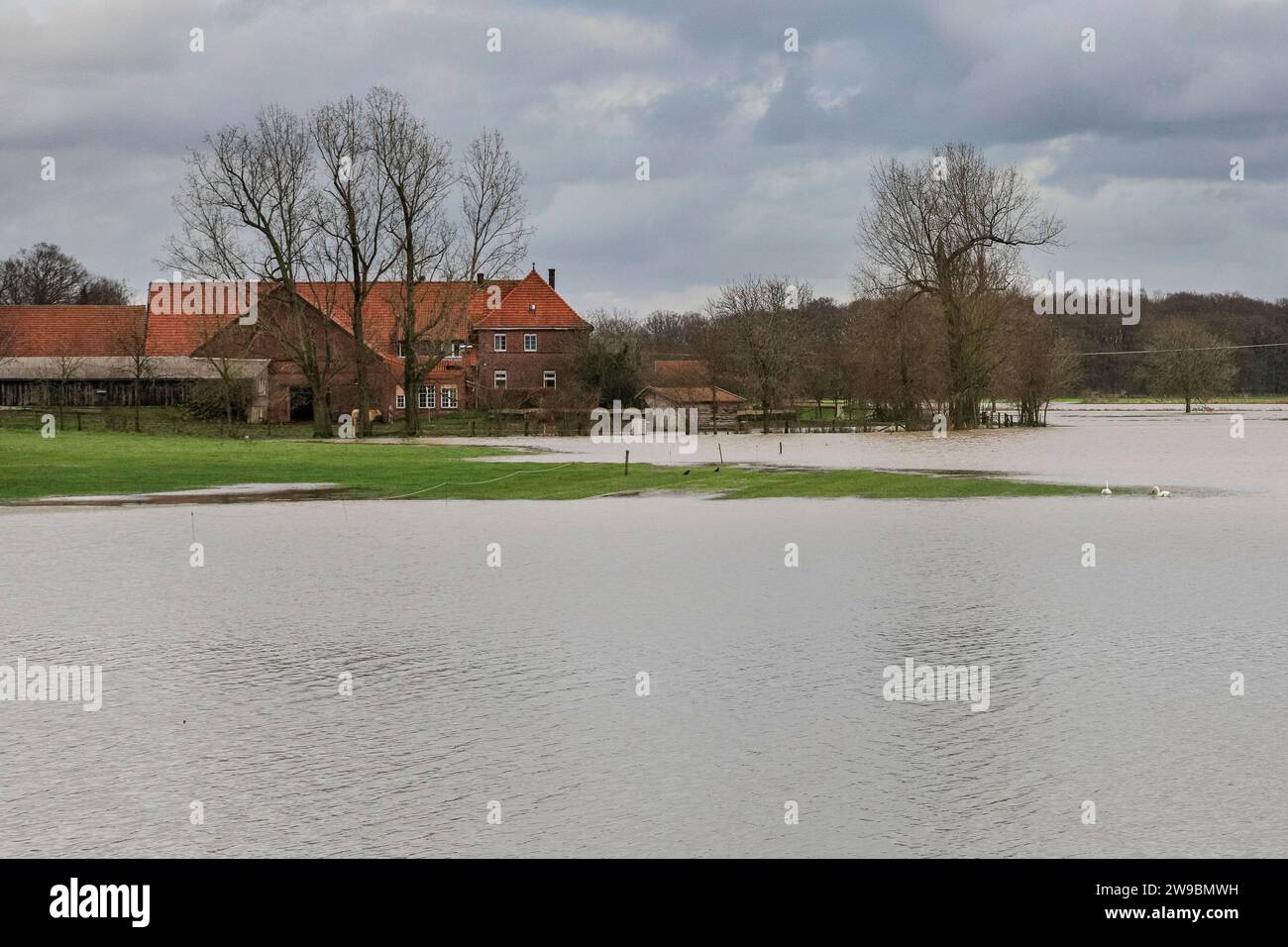 Olfen, NRW, Germania. 26 dicembre 2023. Il fiume Stever e le sue sponde hanno gravemente allagato gran parte della campagna circostante. Vicino al ponte Stever, uno storico ponte a tre archi che trasportava piccole imbarcazioni in un canale sul fiume Stever (ora è un ponte pedonale), i campi circostanti sono allagati al ginocchio. Gran parte della Germania settentrionale e occidentale hanno visto inondazioni dopo settimane di forti piogge. La previsione è per più pioggia. Crediti: Imageplotter/Alamy Live News Foto Stock