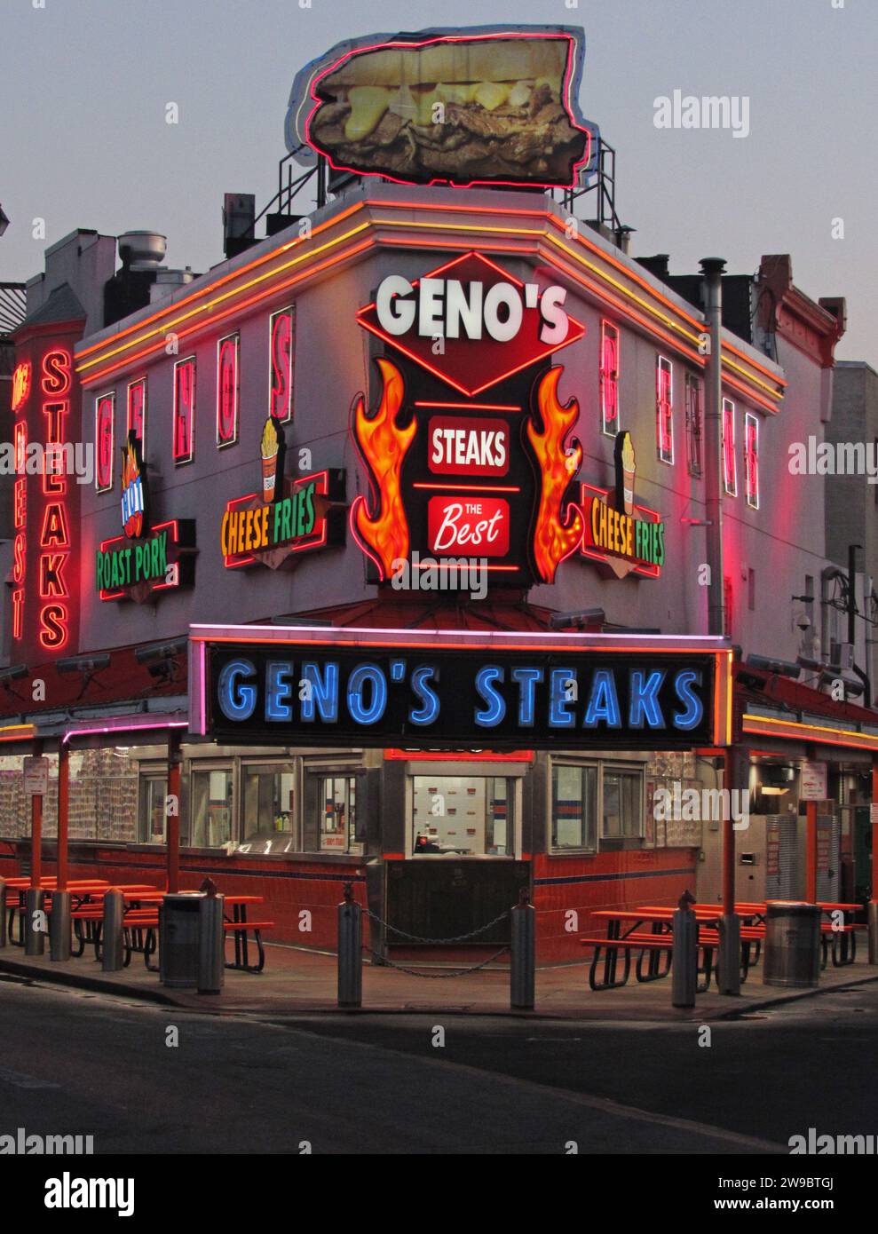 Geno's Steaks, un pilastro del mercato italiano di Filadelfia, si illumina al neon all'alba. Foto Stock