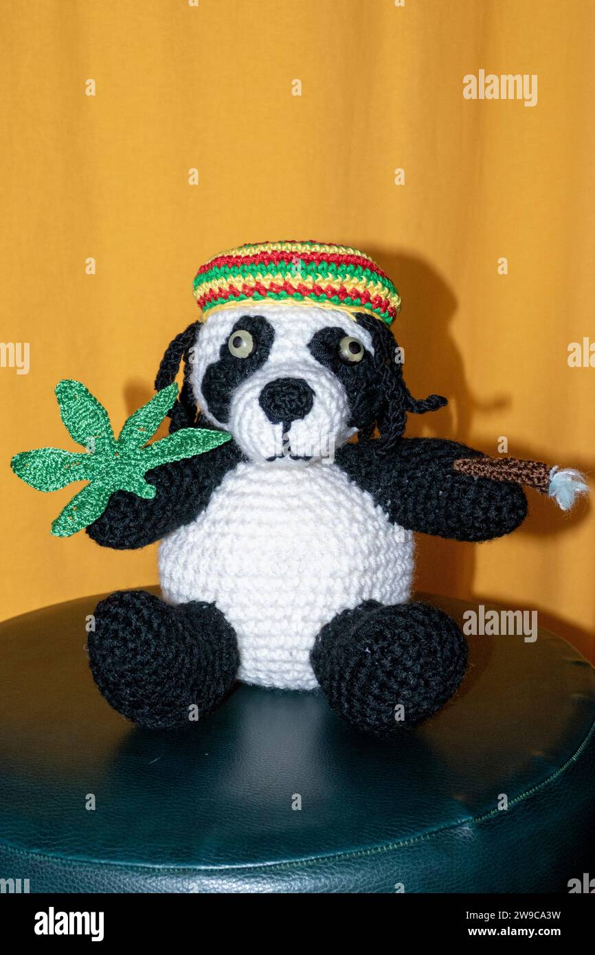 Gehäkelter Reggae Panda Bär mit Jamaika Mütze, Hanf Blatt und Rasterlöckchen Foto Stock
