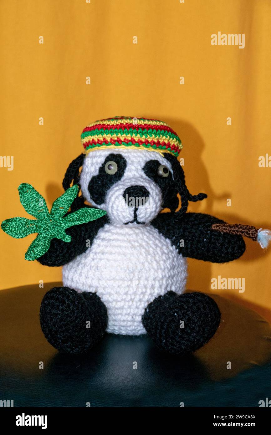 Gehäkelter Reggae Panda Bär mit Jamaika Mütze, Hanf Blatt und Rasterlöckchen Foto Stock