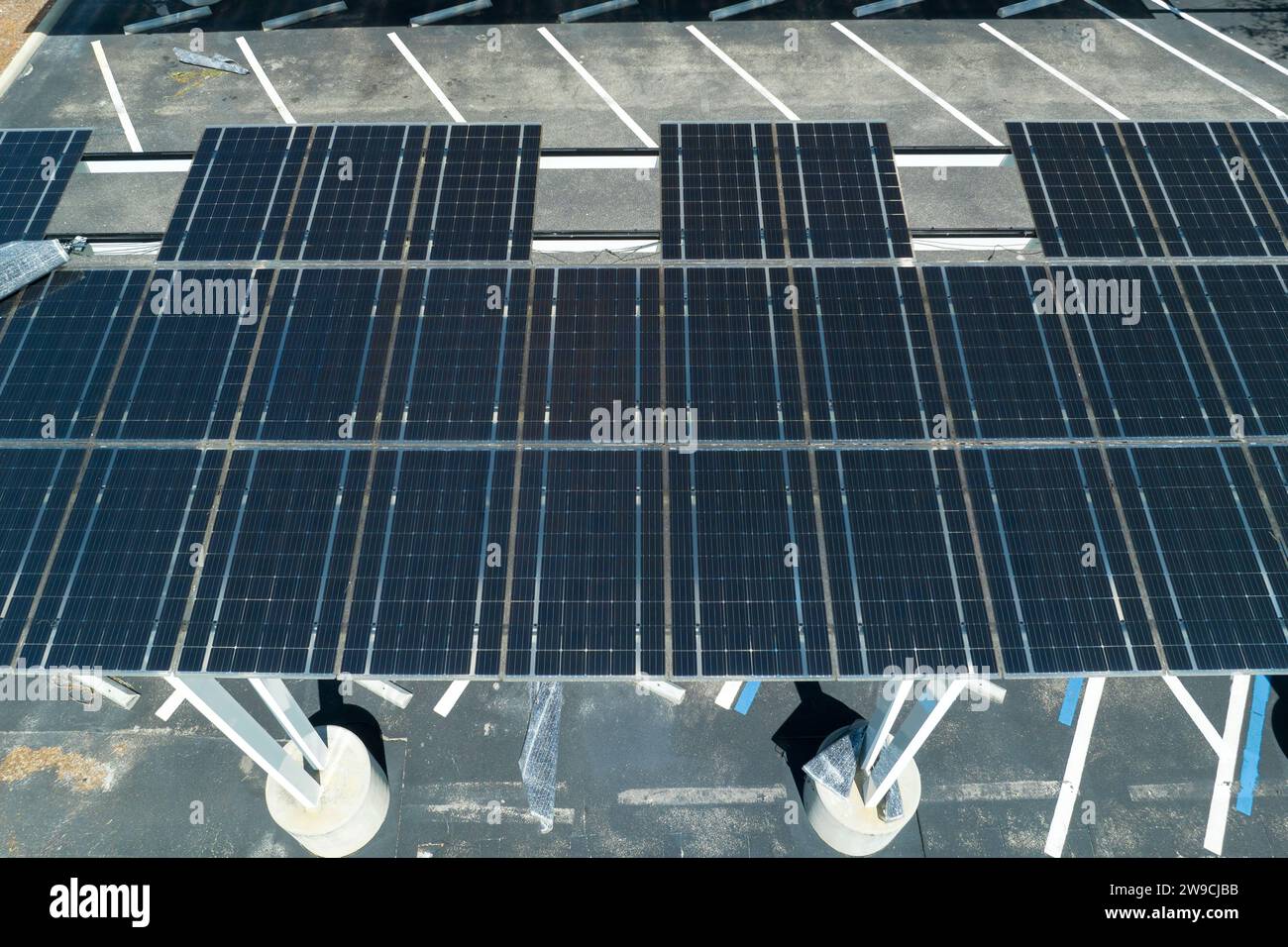 Fallimento della tecnologia fotovoltaica integrata nelle infrastrutture urbane. Danni causati dall'uragano causati dal vento ai pannelli solari installati come tetto ombreggiato sul parcheggio Foto Stock