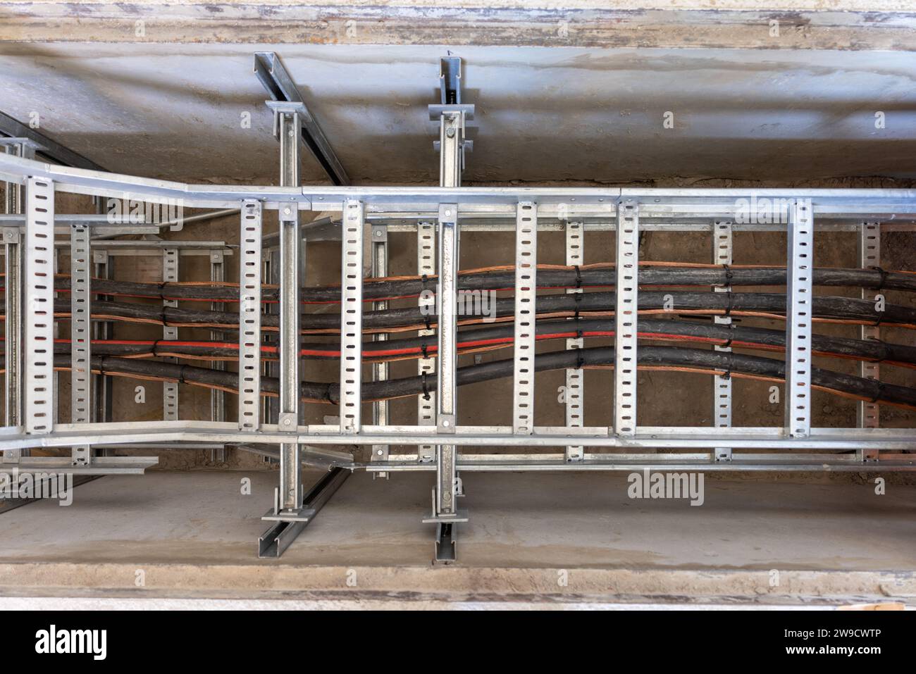 canalina per cavi elettrici su un telaio metallico sotterraneo in una trincea, area industriale di estrazione cavi in un vassoio, canalina per cablaggio industriale, lavorata a maglia Foto Stock