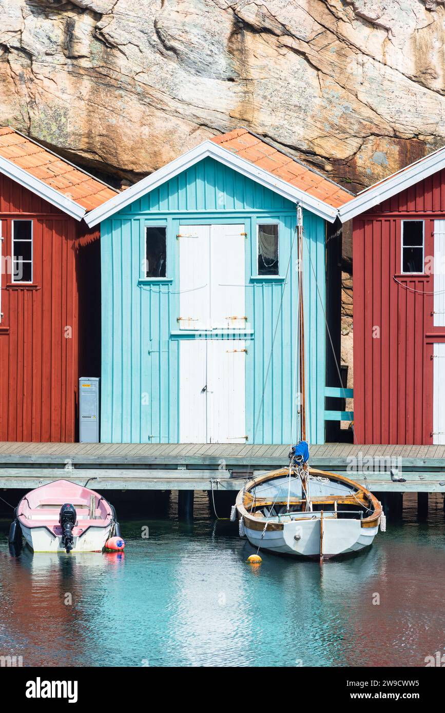 Magazzino con facciata in legno turchese davanti a rocce di granito sul lungomare del porto di Smögen, nell'arcipelago della costa occidentale svedese Foto Stock