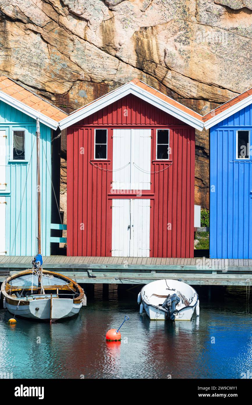 Magazzino con facciata in legno rosso davanti a rocce di granito sul lungomare del porto di Smögen, nell'arcipelago della costa occidentale svedese Foto Stock