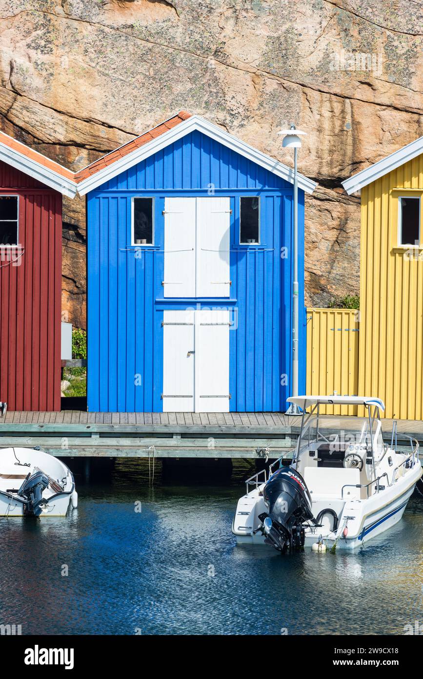 Magazzino con facciata in legno blu davanti a rocce di granito sul lungomare del porto di Smögen, nell'arcipelago della costa occidentale svedese Foto Stock